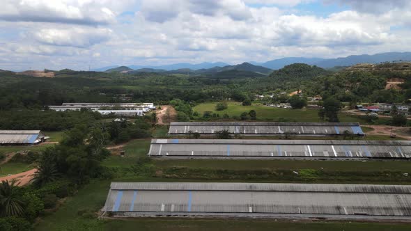 Aerial view of cloudy sky, chicken house and jungle in Malacca