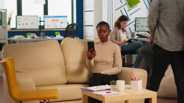 Tired Black Woman Talking with Colleague Using Video Call Holding Smartphone alt