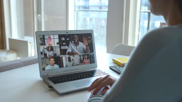 Young Woman Using Laptop for Video Meeting with Group of Diverse People