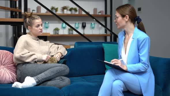 Side View Portrait of Upset Teenage Girl Talking with Professional Psychologist Sitting on Couch alt