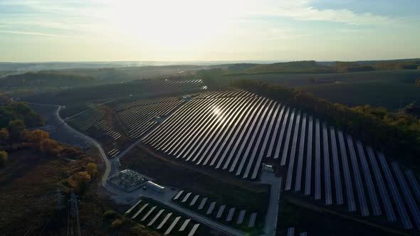 Aerial Drone Footage. Radial Flight Over Solar Panel Farm at Sunset Autumn Season.