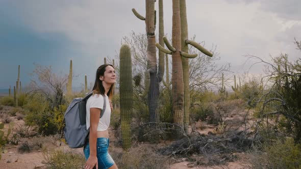 Slow Motion Medium Shot, Happy Young Tourist Woman Hiking at Amazing Wild Cactus Desert in Arizona alt