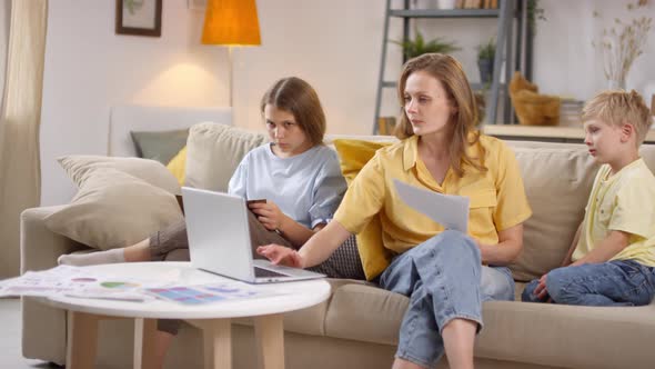 Woman with Two Children Working from Home alt