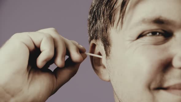 Man Cleaning Ear With Cotton Swab