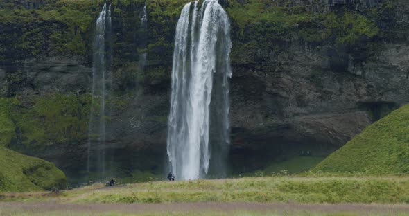 Beautiful Seljalandsfoss Waterfall Iceland From Distance with Unrecognized Tourist Walking Around