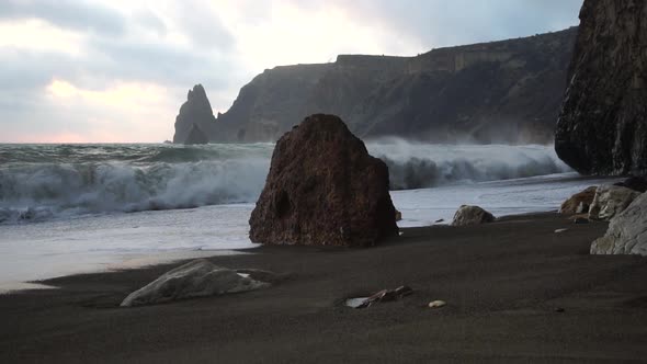 A Red Burning Sunset Over the Sea with Rocky Volcanic Basalt Cliff alt