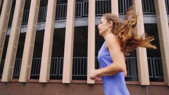 Woman Jogging Against Building in Slow Motion alt