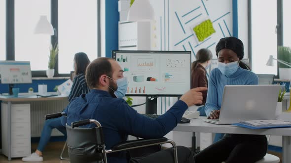 Diverse Coworkers with Face Masks Working Together in New Normal Workplace alt