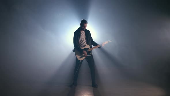 Rock Guitarist Man on Smoky Stage and Masterfully Playing Electric Guitar.  alt