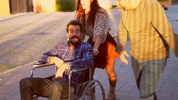 solidarity with a disabled person-friends assist and amuse a man with paraplegia alt