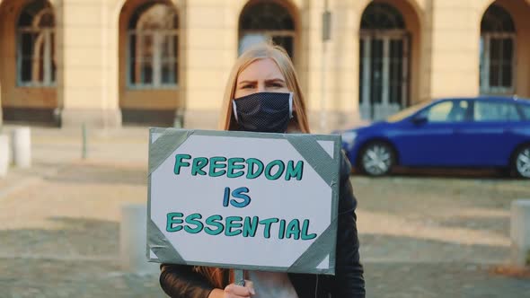 Woman in Mask on Protest Walk Calling That Freedom Is Essential alt
