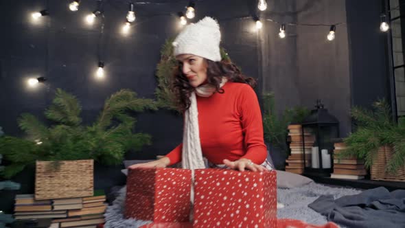 Happy woman with Christmas presents at home. alt