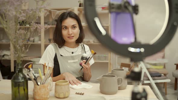 Pottery Master with Supplies Recording Vlog in Studio