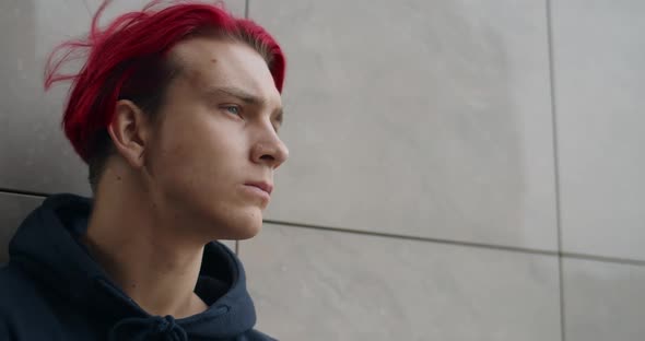 Close Up View of Young Depressed Hipster Man Looking Aside. Portrait of Millennial Guy with Red Dyed