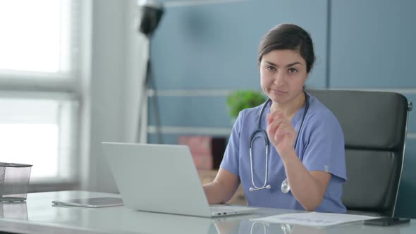 Indian Female Doctor Shaking Head as No Sign while using Laptop in Office alt