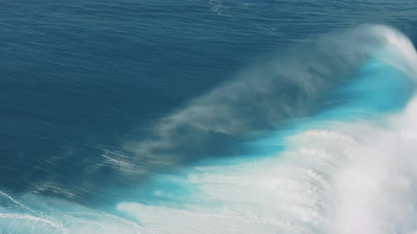 Aerial view of curling ocean waves with splashing wave crest; natural abstract pattern, sea texture
