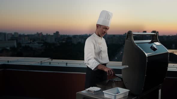 A professional Chef prepares a barbecue on the rooftop of a skyscraper. An expensive restaurant alt