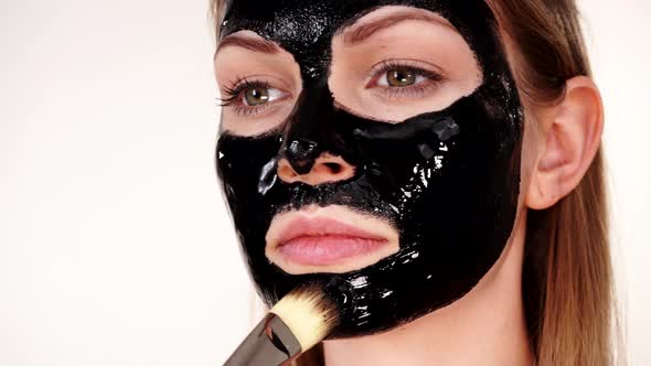 Girl Applying black Mask to Face