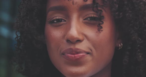 Attractive african woman looks directly at camera and then to her right alt