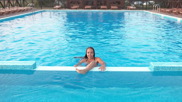 Girl in Leopard Swimsuit Playing in the Pool Under the Summer Sun alt