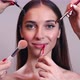 Multiple Hands Doing Make Up of Young Woman