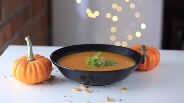 Pumpkin soup and pumpkins on a table