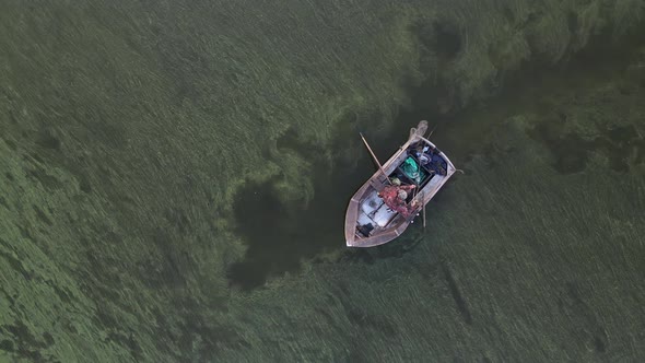 A Fisherman in a Boat Catches Fish in the Sea alt