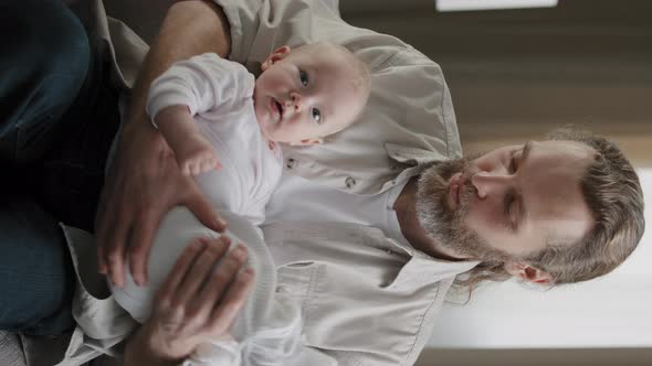Bearded 30s Happy Single Dad Parent Father Sings Lullaby to Newborn Cute Son Daughter Child Infant alt