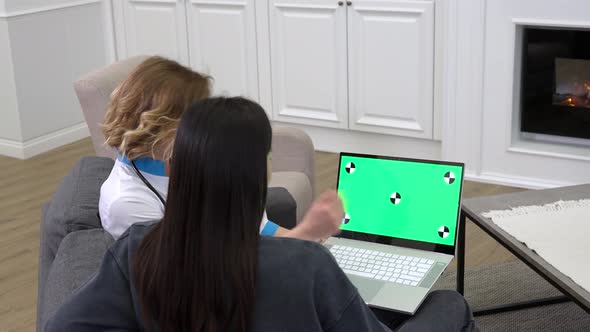 Female Doctor Using Laptop During Medical Consultation at Patient Home