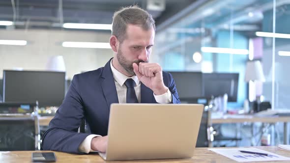 Young Businessman Having Coughing While Working on Laptop alt