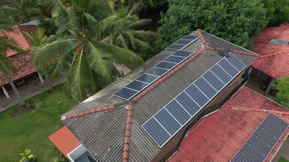 solar panels on the roof, palm trees near the house