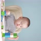 A joyful baby 12-17 months old builds a tower of wooden cubes sitting on a chair. - VideoHive Item for Sale