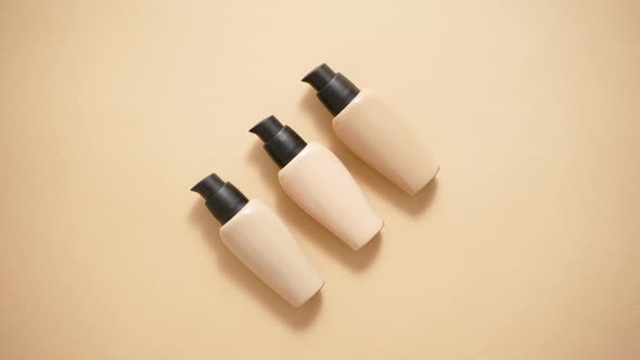 Bottles of Three Different Shades of Makeup Foundation on Beige