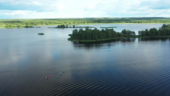 Top View of the Lake Where a Family Swims on Sup Boards at Sunset