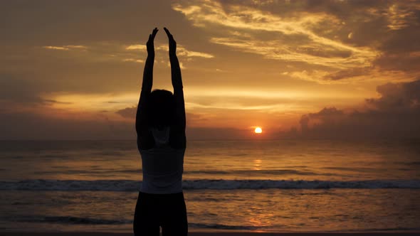 Young Healthy Woman Practicing Yoga on the Beach at Sunset Ocean Waves alt