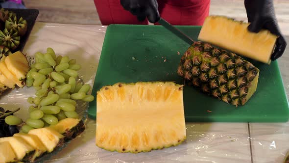 Female Hands Cutting with Knife Ripe Pineapple to Slice alt