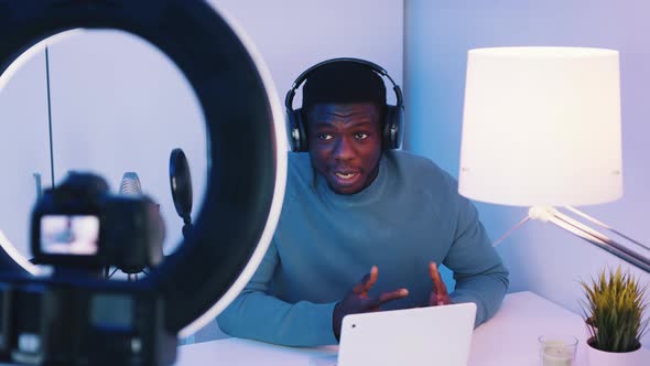 Camera Screen Showing A Man Wearing Headphones Talking While Looking At The Camera alt