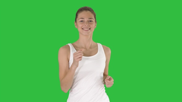 Beautiful sporty woman running on a Green Screen, Chroma Key. alt