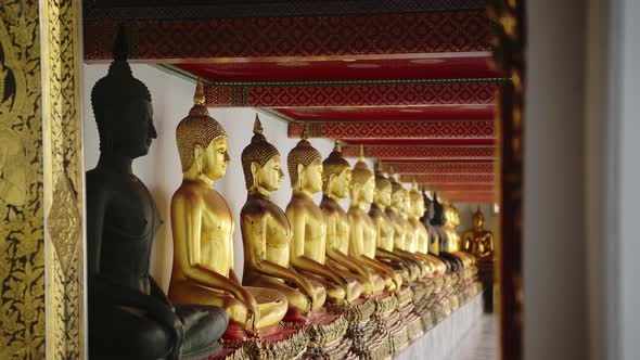 Gold Buddha Statues in Bangkok, Famous Thailand Buildings with a Line of Lots of Buddhist Statues in alt
