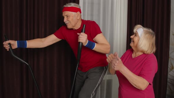 Healthy Elderly Senior Grandfather Model Exercising Sport Workout on Orbitrek in Room at Home alt