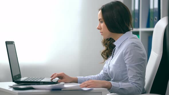 Young Female Using Laptop Computer at Workplace alt