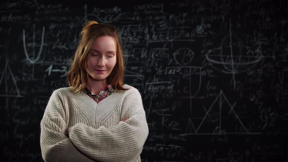 Portrait of Young Female Student Stands in Front of Blackboard with Mathematics Formulas alt