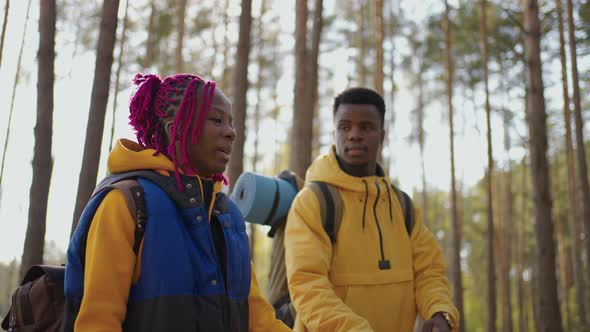 A Young Couple of Black Men and Women Walk in the Woods During a Trip to the Woods with Backpacks in alt