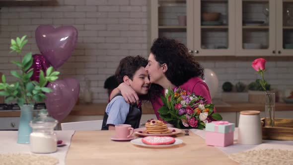Loving Son Giving Festive Flowers To Happy Mom alt