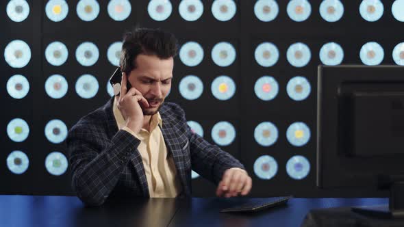 Ambitious Businessman in Stylish Checkered Suit Speaks on Smartphone in Office