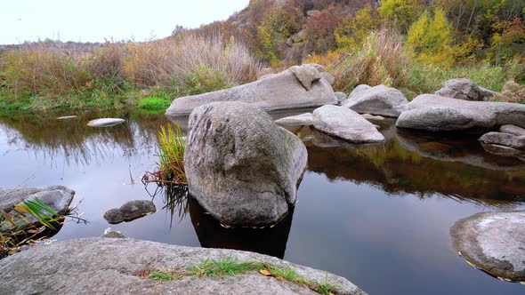 A Fast Clean Stream Runs Among Smooth Wet Stones Surrounded By Tall Dry Lumps alt