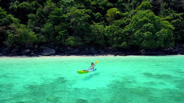 Cute Asian Girl on a Kayak at Monkey Beach Phi Phi Island Thailand