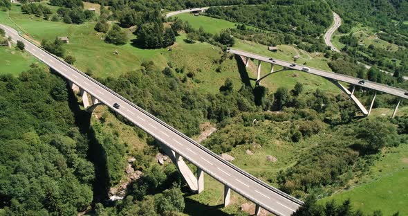Aerial View of Cars Driving a Mountain Road and Bridges Over a Mountain Valley in Alps, Switzerland