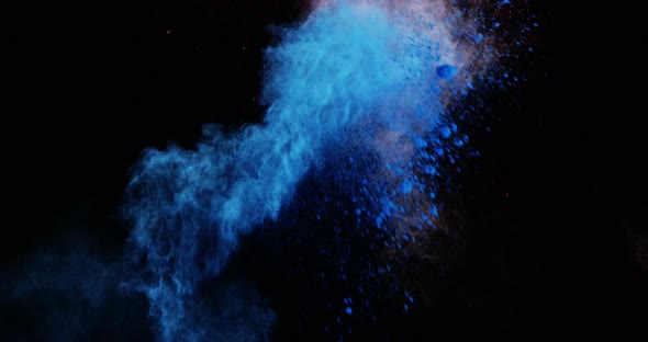 Blue and red dust powder blowing against black background alt