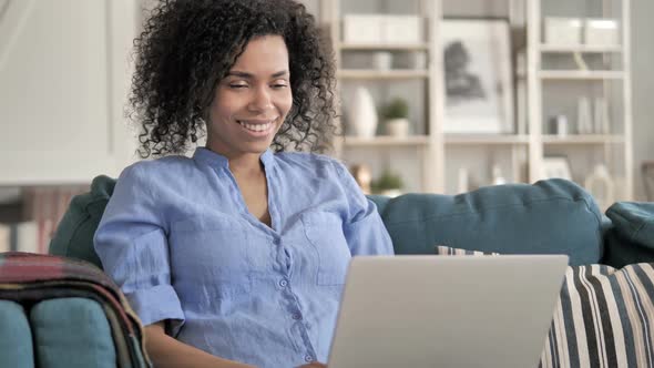 Online Video Chat By African Woman Sitting on Couch alt